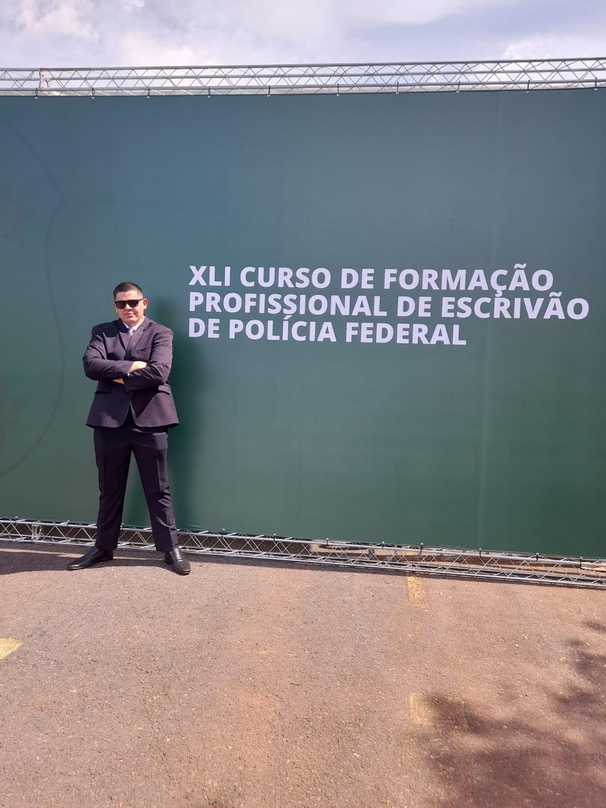 A person standing in front of a sign
Description automatically generated