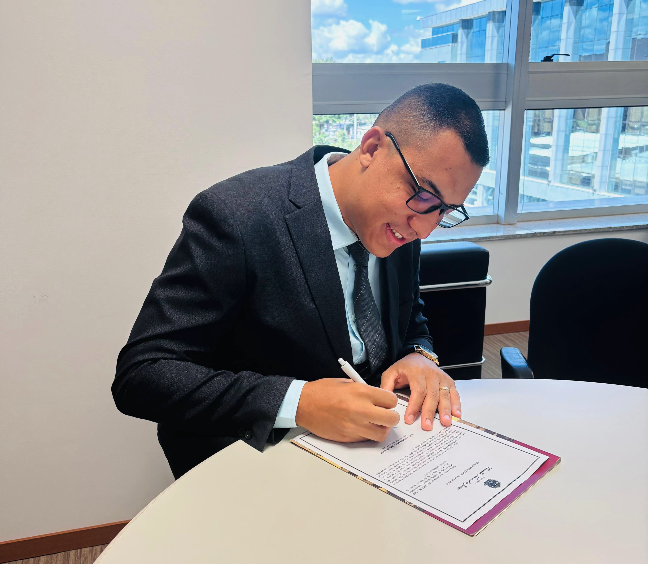 A person in a suit writing on a clipboard

Description automatically generated