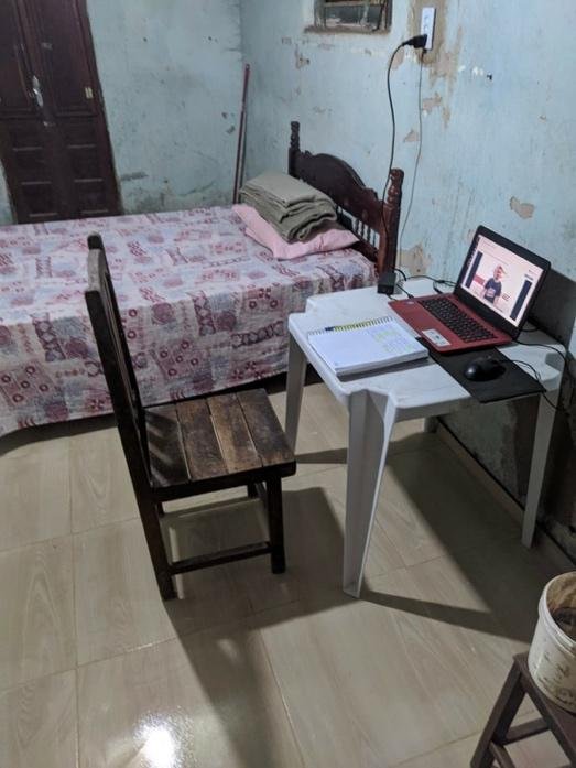 A small room with a bed and a computer on a desk
Description automatically generated