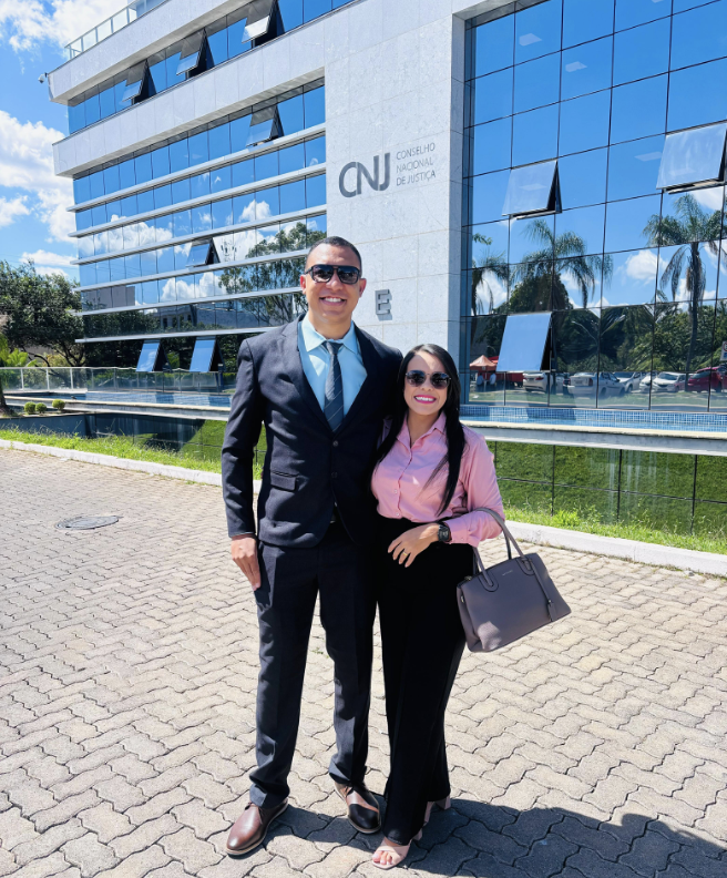 A person and person standing in front of a building

Description automatically generated